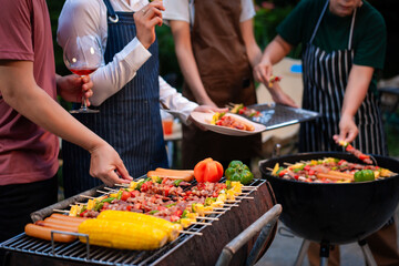 An Asian woman with friends grilling BBQ skewers, corn, and sausages outdoors. They toast with wine amid glowing string lights, creating a joyful and warm evening barbecue atmosphere