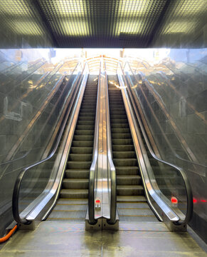 A silver escalator with two sets of stairs