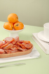 Fresh Loquat Fruits and Dried Fruit Slices with Tea Setting on Green Table