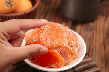 Orange Dried Fruit Candy Confection with Sugar Coating on Rustic Wooden Table