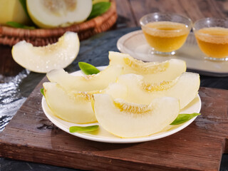 Fresh Honeydew Melon Slices with Tea on Wooden Board - Healthy Sweet Fruit Snack