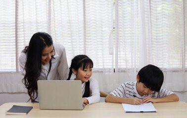 Happiness Asia kid girl and mom smile portrait looking smart phone for learning at home.