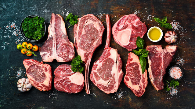 Background of steaks. Fresh aged prime steaks Black Angus. A set of steaks for grilling. Top view.