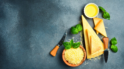 Large set of aged cheese. Top view on a gray stone background. Close-up. Aged cheese cut into pieces.