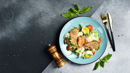 Fresh vegetable salad with chicken fillet and egg. Traditional Caesar salad. In a blue plate.