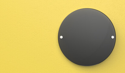Round black signboard on yellow wall, front view