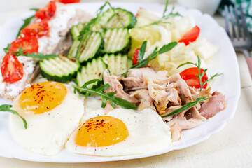 Ketogenic, paleo diet. Fried eggs, boiled chicken and fresh salad. Keto breakfast. Brunch