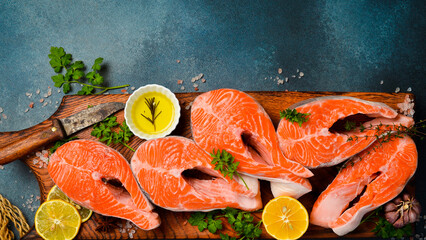 Raw trout steaks seasoned with lime juice, salt and pepper, on a wooden cutting board. Rustic style.