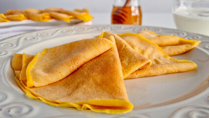 Close-up of crepes with a jar of honey