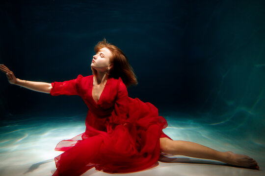 Underwater dance in a flowing red dress creates a magical scene