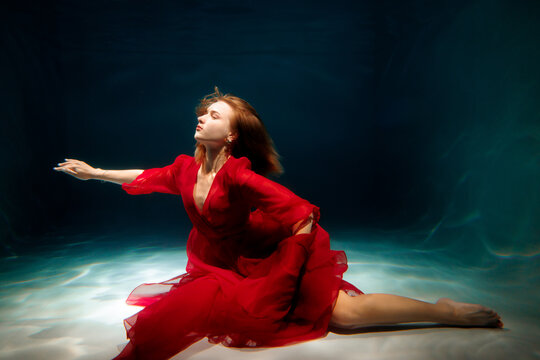 Underwater dance in a flowing red dress captures graceful beauty