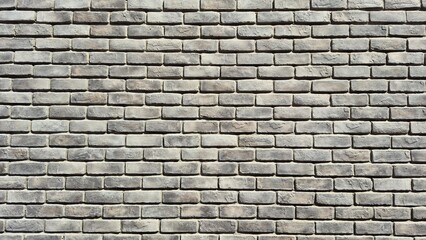 Close-up of a gray brick wall texture. Pattern of rectangular bricks with natural rough surface, suitable for use as a background, construction material, or design element.