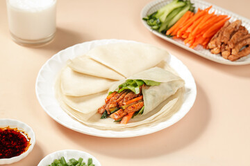 Handmade Asian Spring Rolls with Shredded Pork and Fresh Vegetables on White Plate