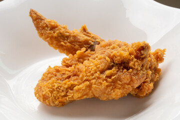 crispy fried chicken on white plate close up