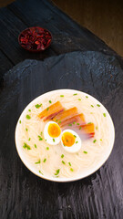 Asian Ramen Noodle Soup with Bacon and Soft Boiled Egg on Dark Slate Background