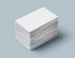 A large, neatly stacked pile of blank rectangular white business cards (or name cards) at an angle, casting a subtle shadow on a clean, solid light gray-blue surface.