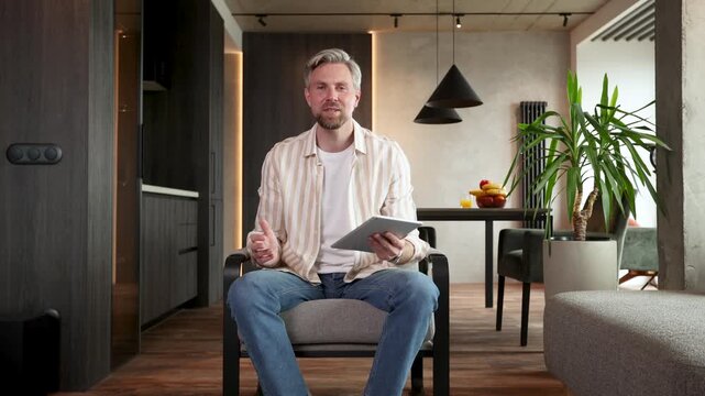 Young bearded man in shirt recording video message. Concept of communication, blogging, technology