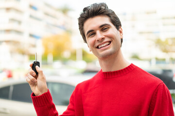 Young handsome man holding car keys with happy expression