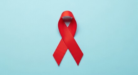 A single red awareness ribbon for HIV/AIDS, isolated on a solid light blue background. World AIDS Day concept.