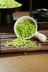 Fresh Green Wheat Kernels in White Ceramic Scoop on Rustic Wood Background