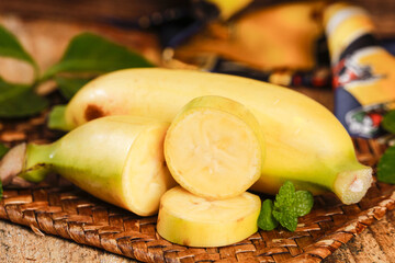 Fresh Peeled Bananas with Slices on Wicker Basket with Mint Leaves