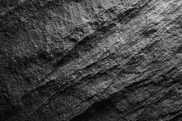Obraz premium Close-up shot revealing the textured surface of dark gray stone, displaying a layered look
