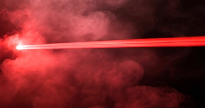 Red laser beam through smoky haze