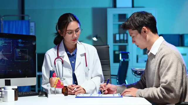 Doctor showing heart model and medication bottle to patient  for cardiology, medical education, and healthcare communication.