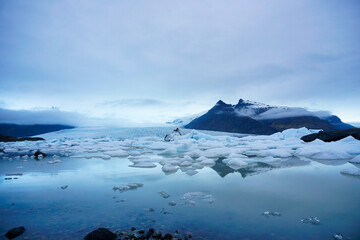 Wide Arctic Landscape of Glacial Lake with Floating Ice and Majestic Peaks