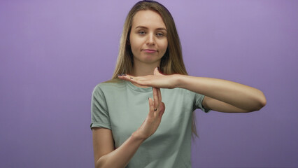 Woman gesturing timeout with eyes closed against purple background, expressing pause or reflection...