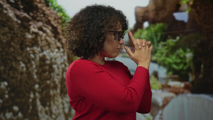 Woman wearing red sweater points finger forward in green forest; growth empowerment resilience...