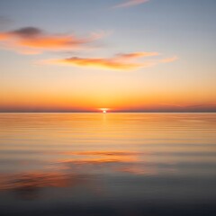 Fototapeta premium Golden Sunset Over Calm Ocean Waters with Reflective Surface and Soft Clouds.