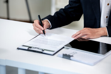 Businessman signing documents on desk in office
