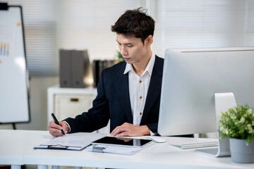 Businessman signing documents on desk in office