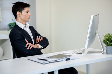 A businessman is discussing work with a client at a desk in an office.