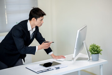 A businessman is discussing work with a client at a desk in an office.