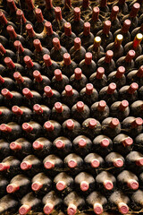 Rows of wine bottles arranged in perfect symmetry at wine cellar