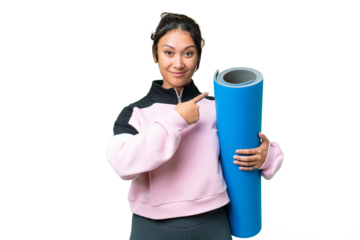 Young sport woman going to yoga classes while holding a mat over isolated chroma key background pointing back