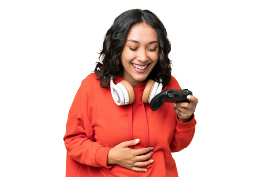 Young Argentinian woman playing with a video game controller over isolated background smiling a lot