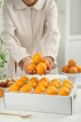 Fresh Apricots from Shandong China - Woman Holding Organic Stone Fruit in White Kitchen