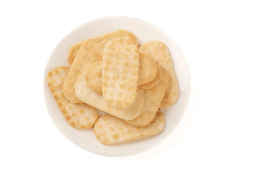 Crispy Golden Rice Crackers in White Bowl on White Background