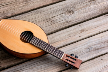 Obraz premium Classic lute resting on contemporary wooden bench under soft natural light, evoking warm nostalgic mood