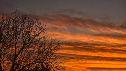 The red-crimson and orange evening sky over the city. Fiery sunset.