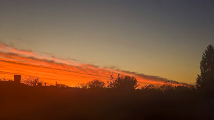 The red-crimson and orange evening sky over the city. Fiery sunset.