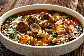 Italian Meatballs Wedding Soup on wooden table	