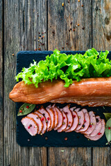 Smoked pork tenderloin on wooden table. Top view