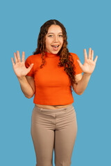 Young woman showing ten fingers expressing surprise standing