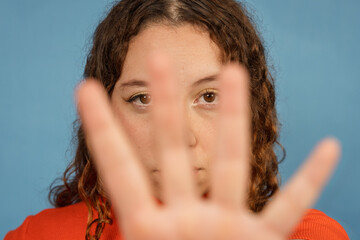 Young woman hiding face with hand showing shyness
