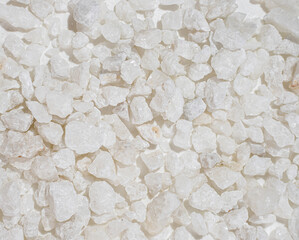 Close-up texture of natural white quartz stones under bright sunlight creating a clean mineral background