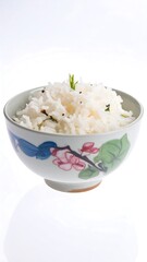 Bowl of steamed white rice with a floral decorated bowl against a bright background